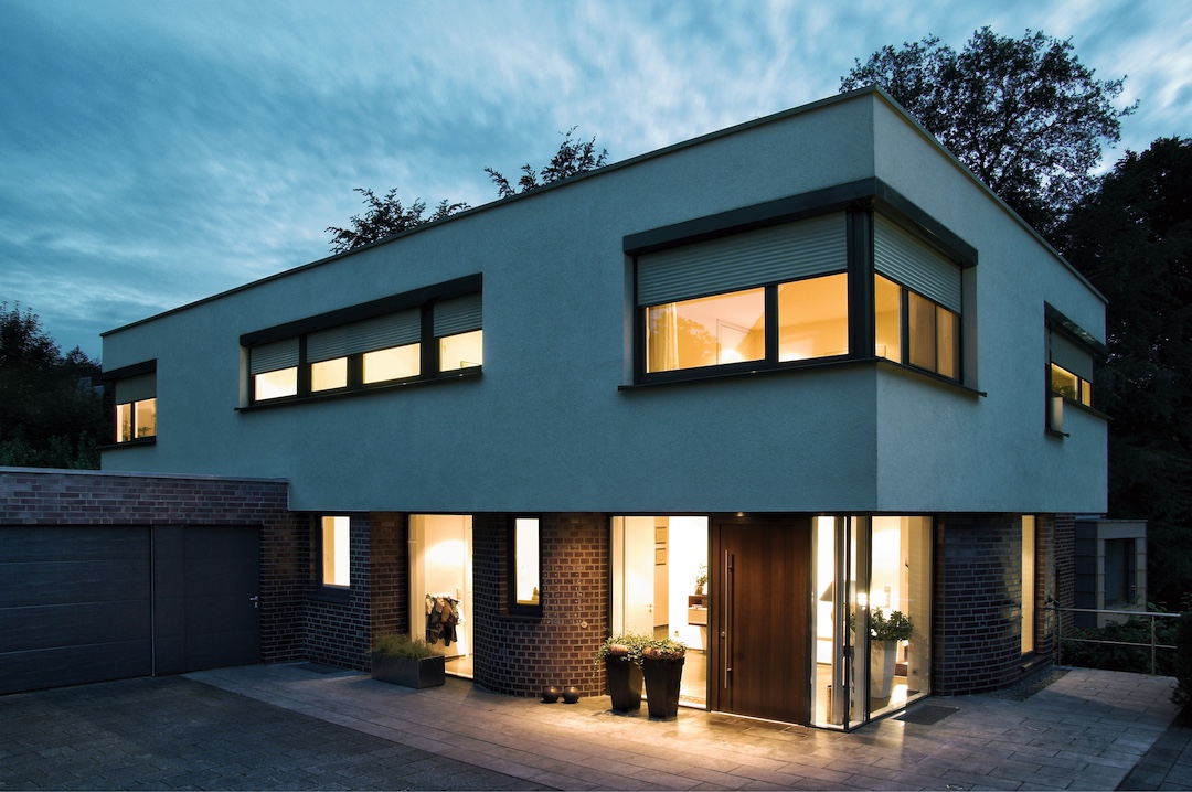 Hausfassade zur Abenddämmerung mit Roma Rolladen.