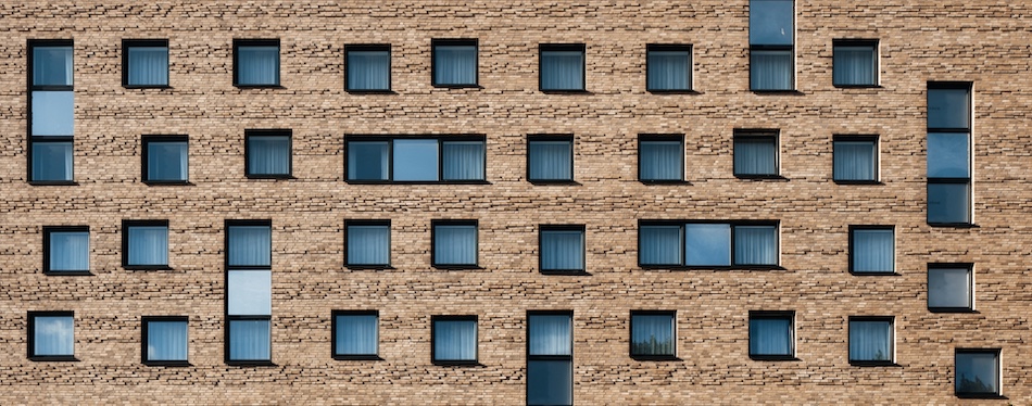 Blick auf Hauswand mit quadratischen Fenstern.