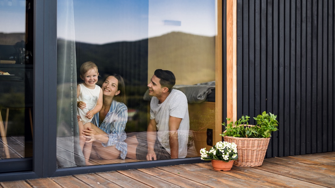 Glückliche Familie vor moderner Terrassentür